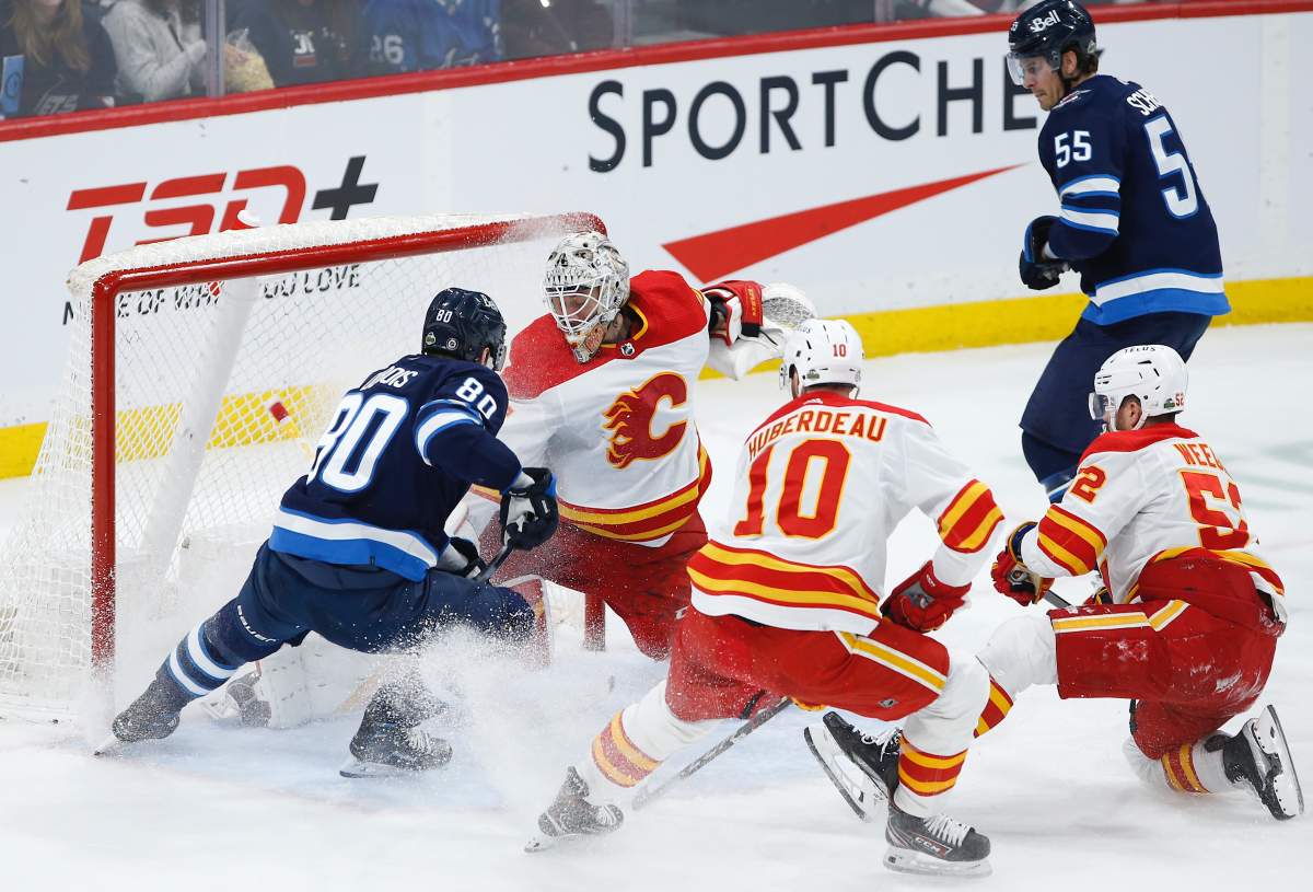 Calgary Flames goaltender Jacob Markstrom (25) saves the shot from Winnipeg Jets’ Pierre-Luc Dubois (80) as Jonathan Huberdeau (10) and MacKenzie Weegar (52) defend during second period NHL action in Winnipeg, Wednesday, April 5, 2023.
