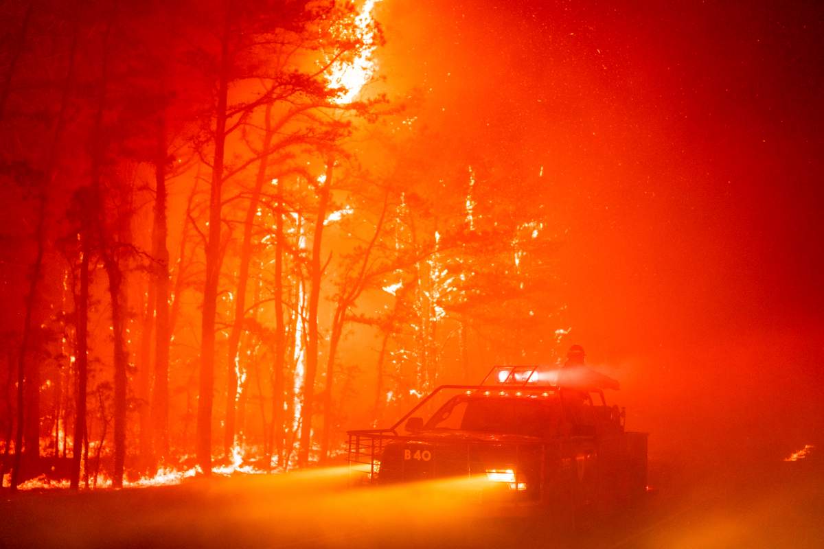 In this photo provided by the New Jersey Department of Environmental Protection, a massive 2,500-acre forest fire burns in Ocean County, N.J., early Wednesday, April 12, 2023, as firefighters battle the blaze. The fire started late Tuesday, April 11, and is burning across some 2,500 acres (about 1,000 hectares). (New Jersey Department of Environmental Protection via AP)