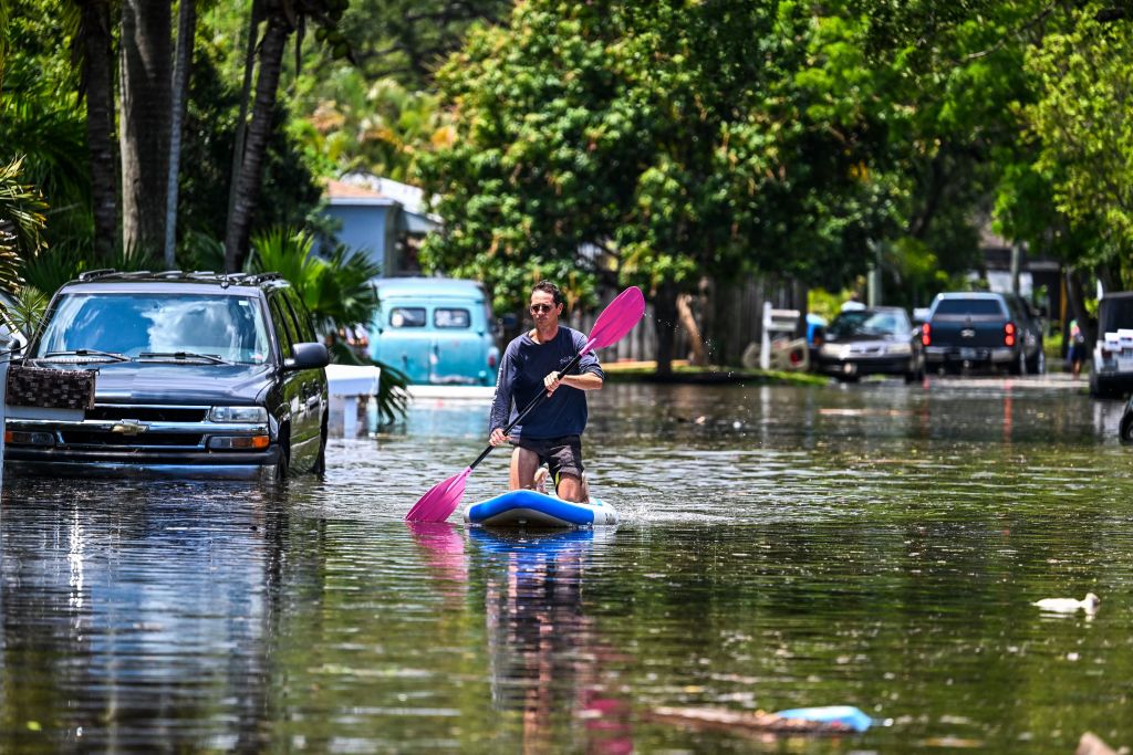 A man paddles on the flooded neighborhood after heavy rain in Fort Lauderdale, Florida on April 13, 2023.