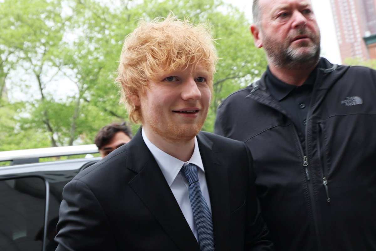 Ed Sheeran in a suit and blue tie.