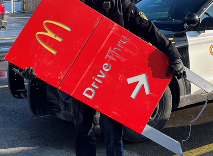 An OPP officer holds a sign for a McDonald's drive-thru.