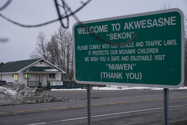 A sign and a dispensary, left, greet visitors on the main road through the reservation Mohawks call Akwesasne, Monday, March 14, 2022, in St. Regis, N.Y.  