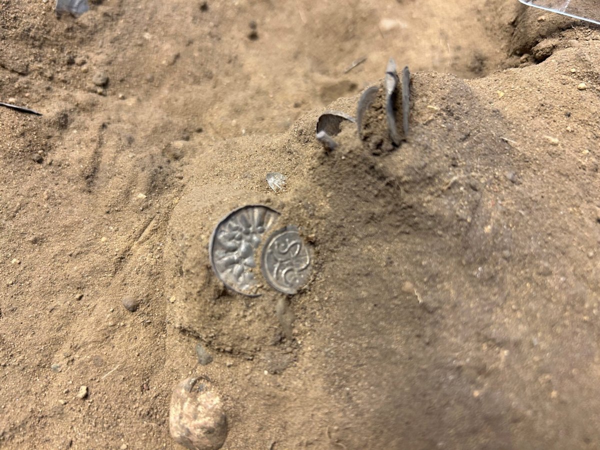 Two silver coins in the sand.