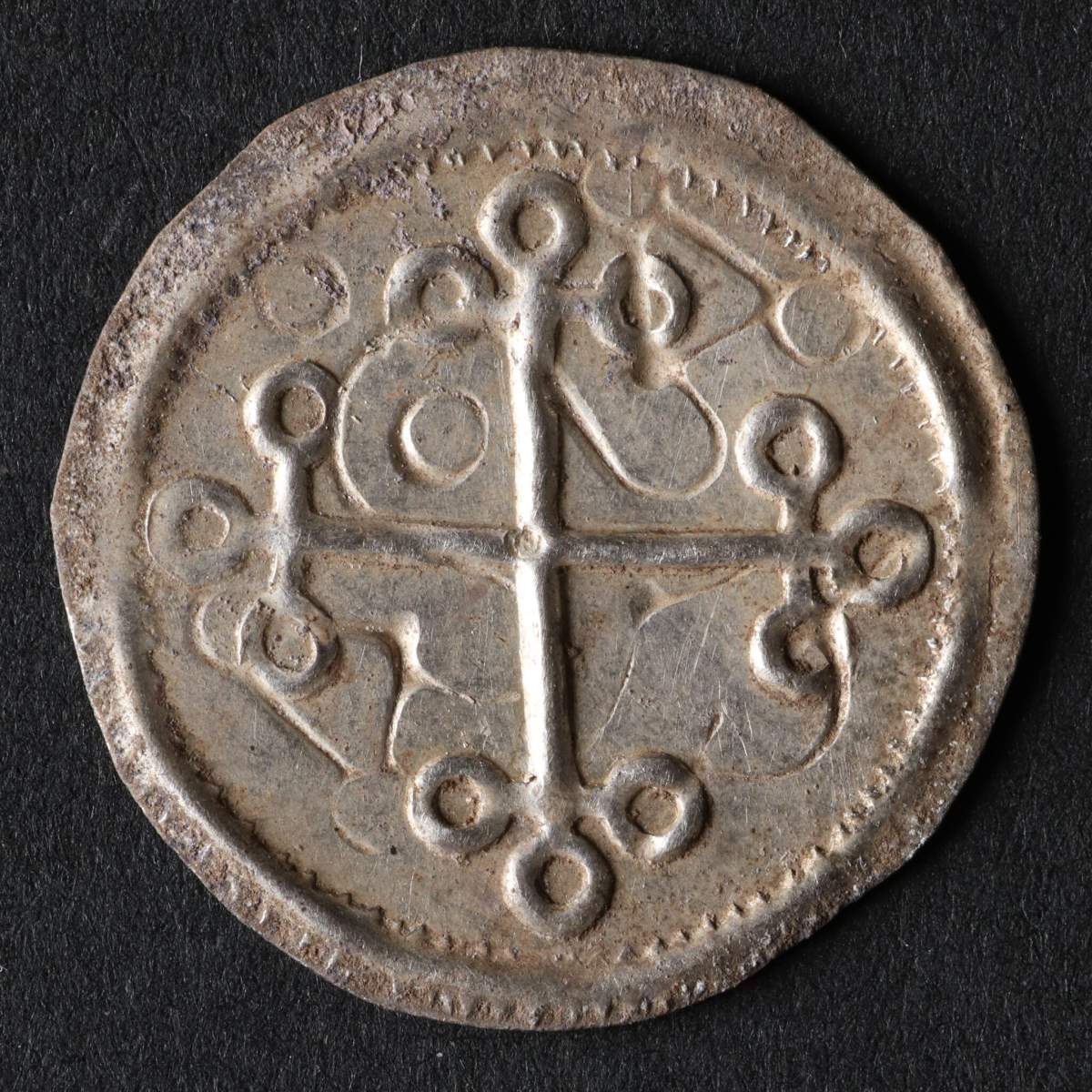 A Dutch coin from the 980s. There is a cross on the coin.