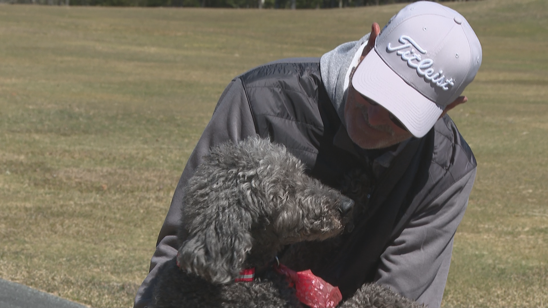 Andrew McGrath stops to greet one of the dogs walking with its owners at the Granite Springs Golf Club.