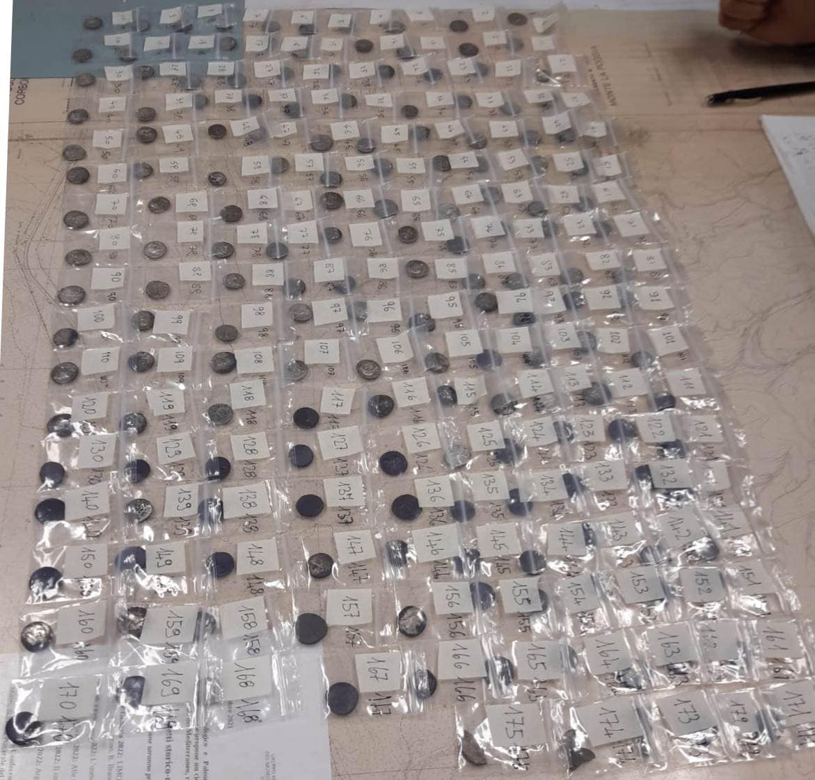 Coins laid out in numbered bags.
