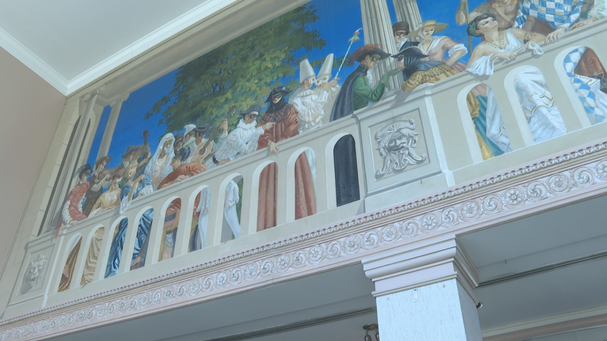 A mural is painted on the walls of regals and jesters — a tribute to live theatre — that has withstood the test of time.