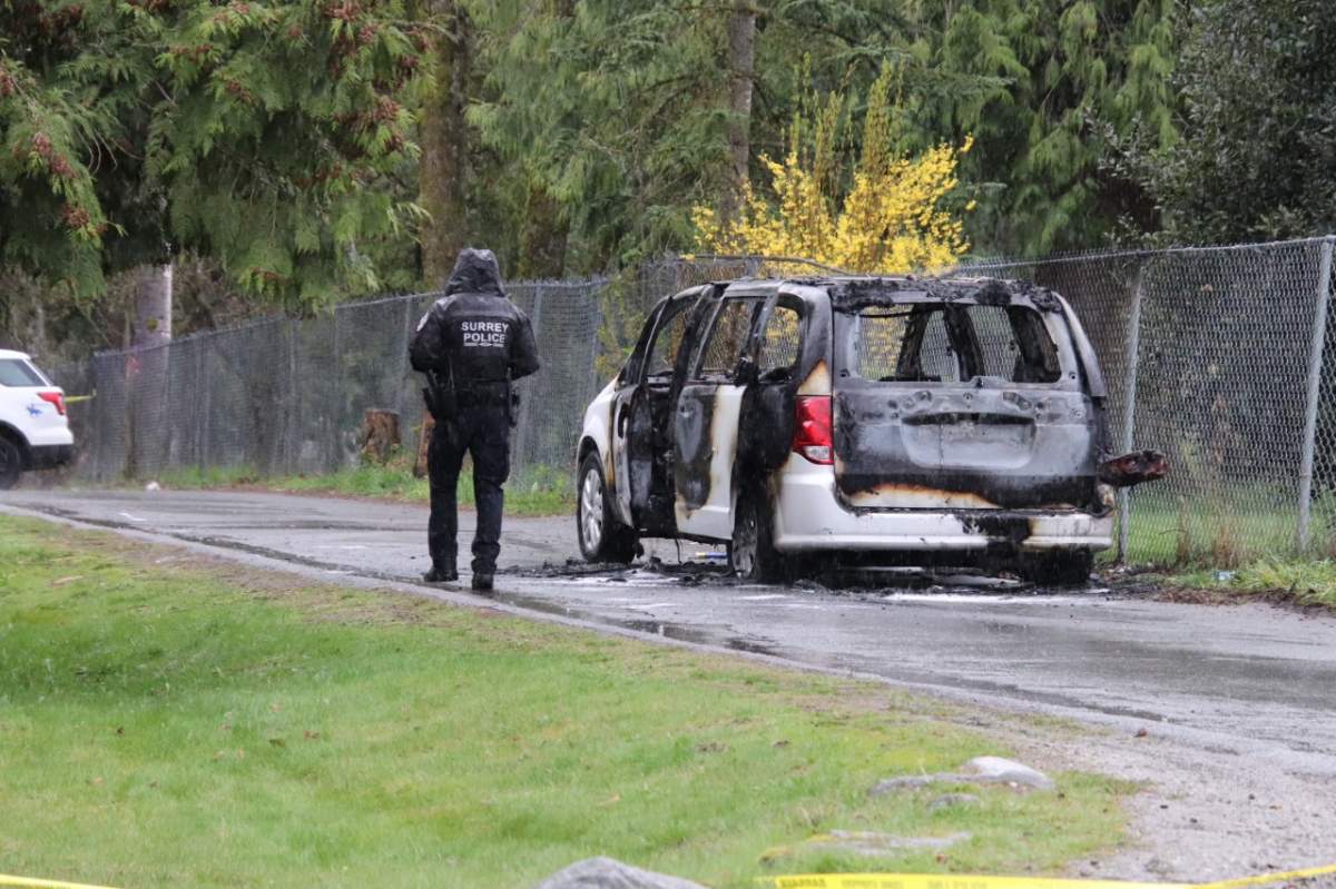 A burned vehicle is seen near 147th Street and 69th Avenue shortly after RCMP received reports of shots fired at a vehicle near 76th Avenue and 148th Street in Surrey, B.C. on Mon. April 17, 2023.