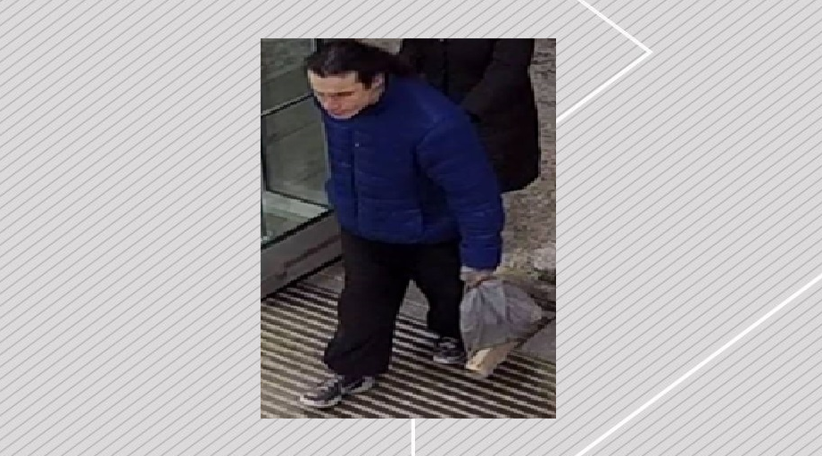 Male suspect in blue jacket and black pants.