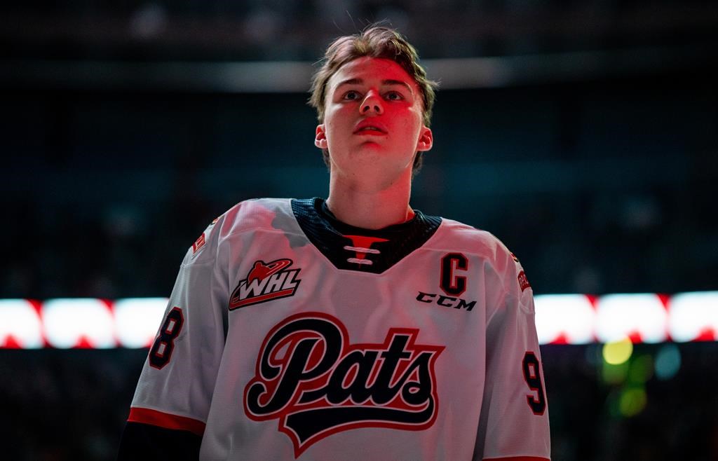Regina Pats forward Connor Bedard (98) lines up prior to WHL playoff hockey action against the Saskatoon Blades in Saskatoon, Sask. THE CANADIAN PRESS/Heywood Yu.
