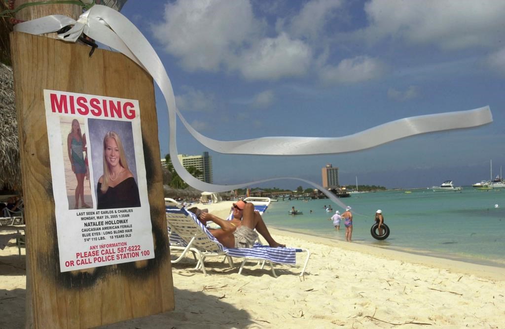FILE - A sign of Natalee Holloway, an Alabama high school graduate who disappeared while on a graduation trip to Aruba, is seen on Palm Beach, in front of her hotel in Aruba, Friday, June 10, 2005.