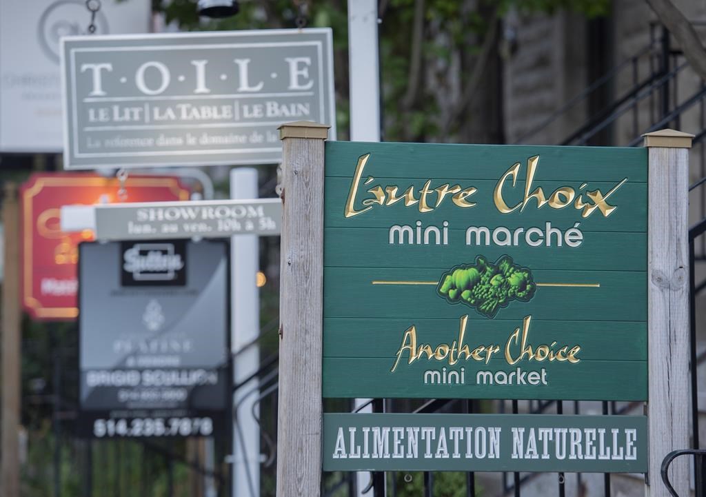 A bilingual sign for a mini market is shown in the city of Westmount, on the Island of Montreal, Friday, Aug. 5, 2022. All the municipalities in Quebec that were at risk of losing their bilingual status under a provincial language law have opted to maintain their right to serve customers in both English and French. THE CANADIAN PRESS/Graham Hughes.