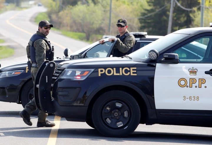 OPP officers stand near the scene of a shooting where one Ontario Provincial Police officer was killed and two others were injured in the town of Bourget, Ont., on Thursday, May 11, 2023. An investigation has begun into whether police fired a gun during the incident. 
