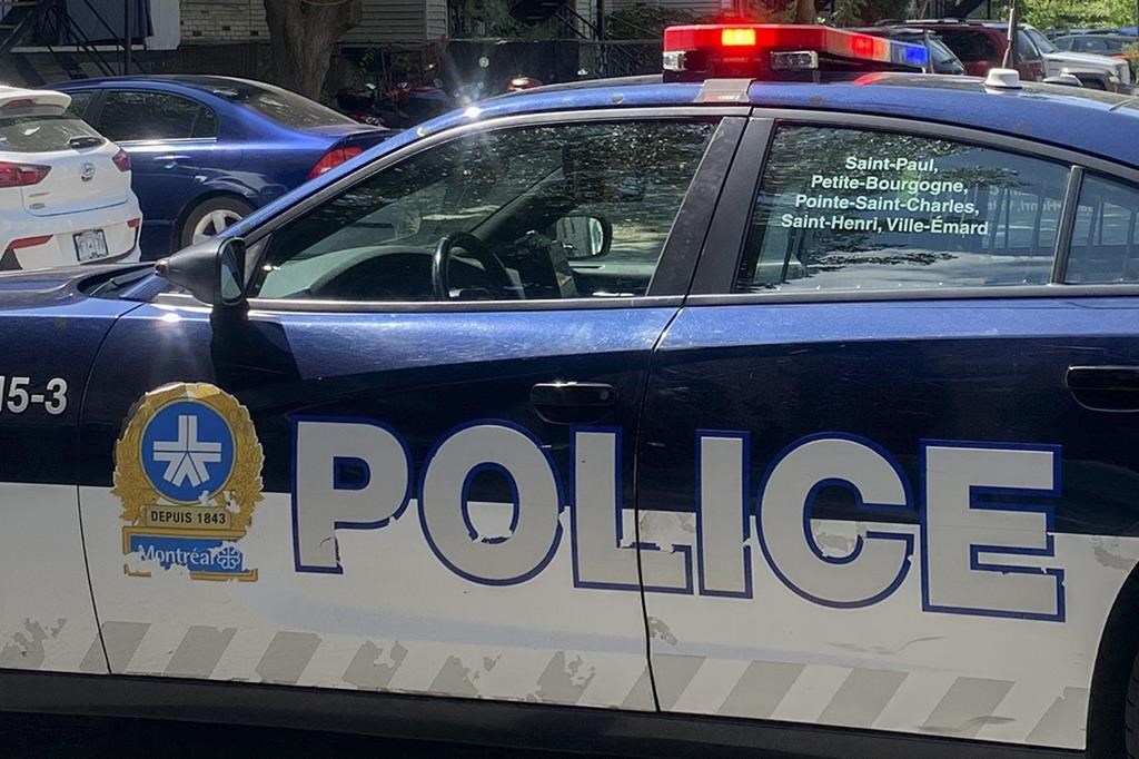 A police cruiser is shown at an apartment building in Montreal, Sunday, Aug. 7, 2022. 
