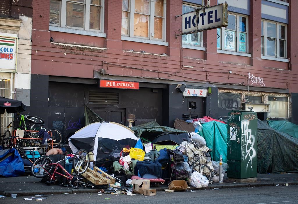 Tents line the sidewalk on East Hastings Street in the Downtown Eastside of Vancouver, on Thursday, July 28, 2022. The B.C. government says it's providing $11 million in grant funding to a Downtown Eastside non-profit aimed at training and empowering tenants of single-room occupancy hotels.THE CANADIAN PRESS/Darryl Dyck.