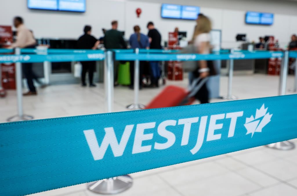 A line at the WestJet counter at the airport in Calgary, Alta., Thursday, May 18, 2023.