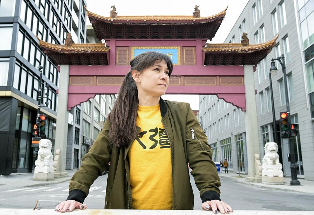Karen Cho, director of Big Fight in Little Chinatown, poses next to the entrance to Chinatown in Montreal, Saturday, May 20, 2023. Chinatowns across North America don't just share a similar look — they also face similar existential threats, and similar David-versus-Goliath-like battles for survival. THE CANADIAN PRESS/Graham Hughes.