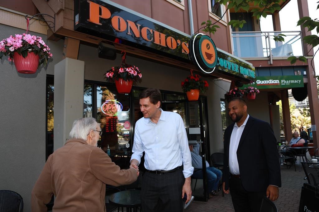 Premier David Eby and BC NDP candidate Ravi Parmar walk along Goldstream Ave. as they visit shops and talk to locals while out in Langford, B.C., on Thursday, May 25, 2023.