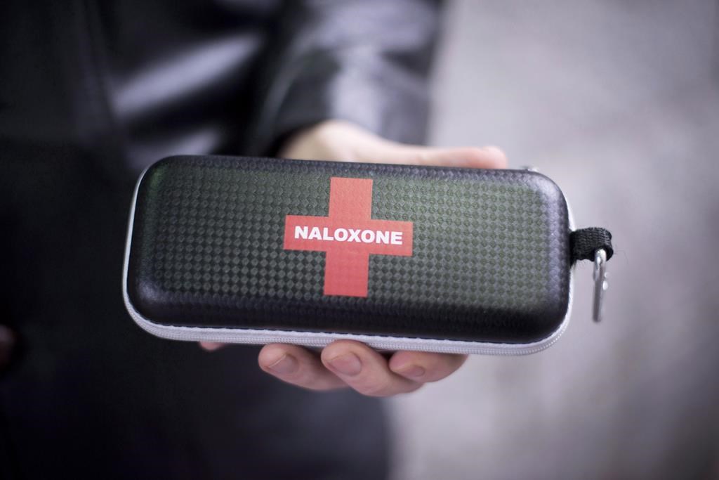 A naloxone anti-overdose kit is held.