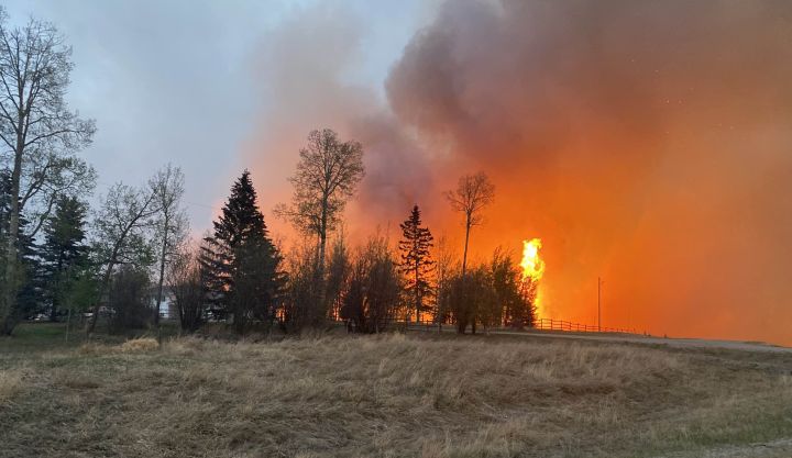 A house is seen burning about 50 kilometres north of Edson, Alta., on May 5, 2023.