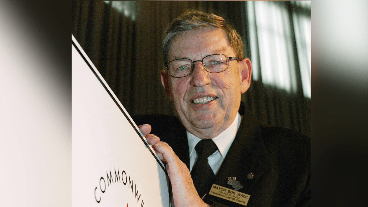 Hamilton Mayor Bob Wade stands beside a poster after his city beat out the city of Halifax for the Canadian bid to host the 2010 Commonwealth games, in Ottawa, Monday December 16, 2002.