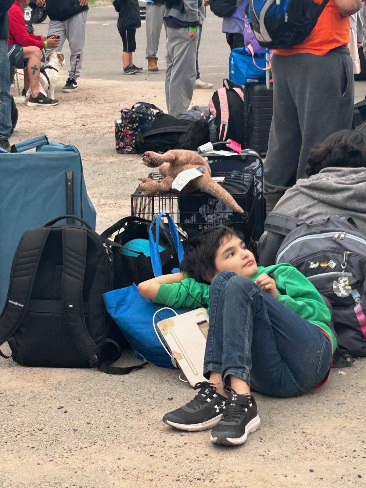 A child, luggage and pet crate waiting at the airport to be airlifted out of Fort Chipewyan because of a nearby wildfire on Tuesday, May 30, 2023.