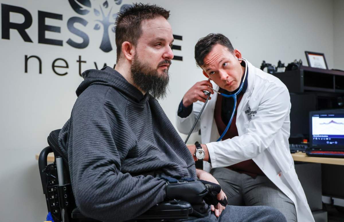 Dr. Aaron Phillips, right, takes the blood pressure of study participant Nick Wiltshire. Researchers at the University of Calgary are developing new technologies for people living with neurological disorders, in Calgary, Friday, April 28, 2023.