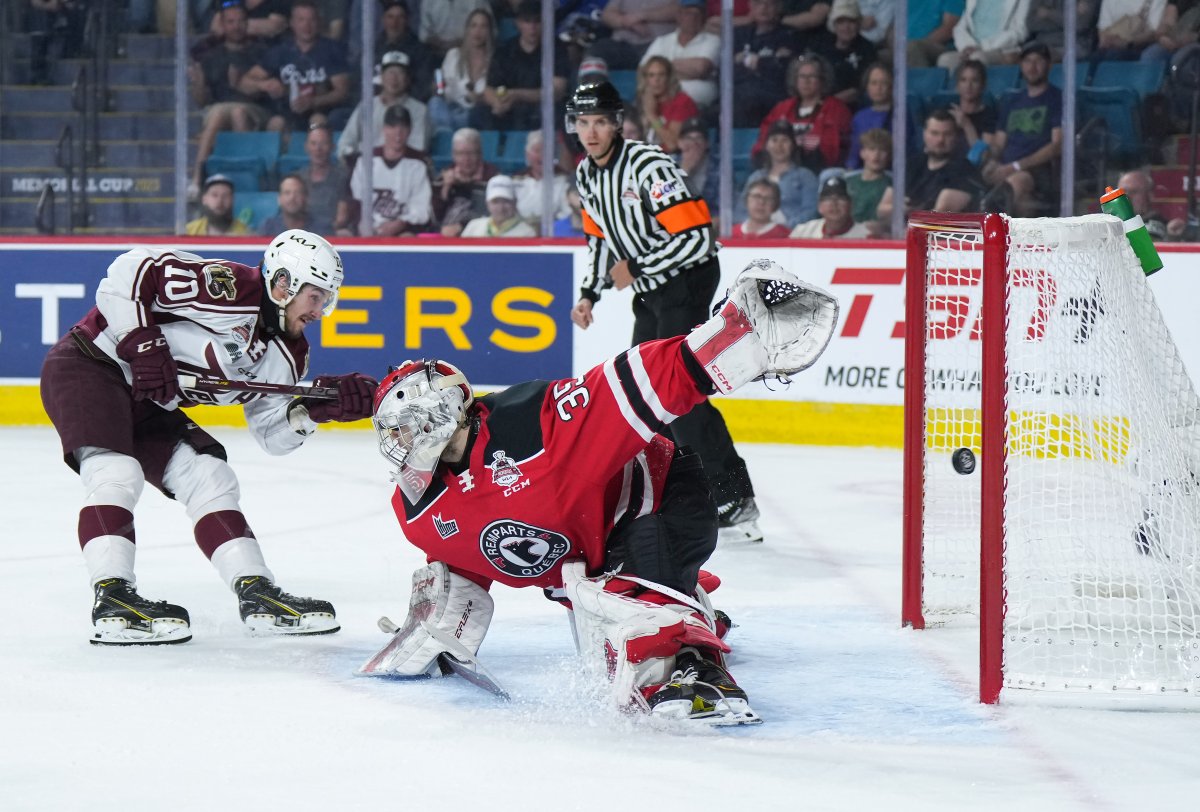 Peterborough Petes' J.R. Avon scores against Quebec Remparts goalie William Rousseau during second period Memorial Cup hockey action, in Kamloops, B.C., on Tuesday, May 30, 2023. 