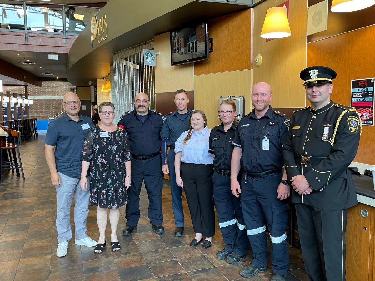 Élyse Martel, second to the left, is joined by first responders and her husband who helped save her life when she entered cardiac arrest last year. 