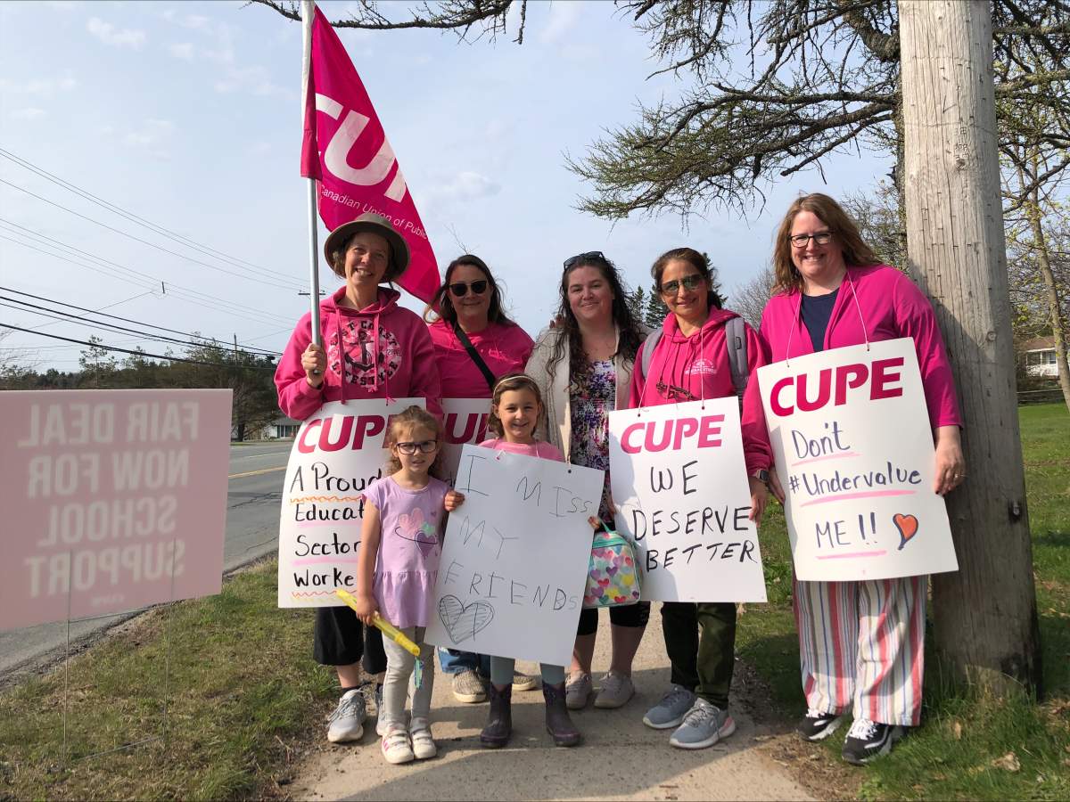 Avery, 4, and Rosie 5, stand with their school support workers who are on strike outside Harold T. Barrett Junior High in Beaver Bank on Thursday, May 11th, 2023.