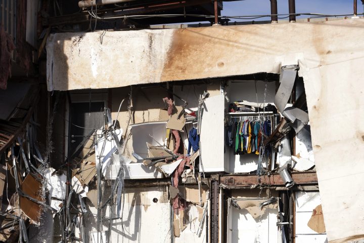 The contents of an apartment can be seen surrounded by debris after an apartment building partially collapsed