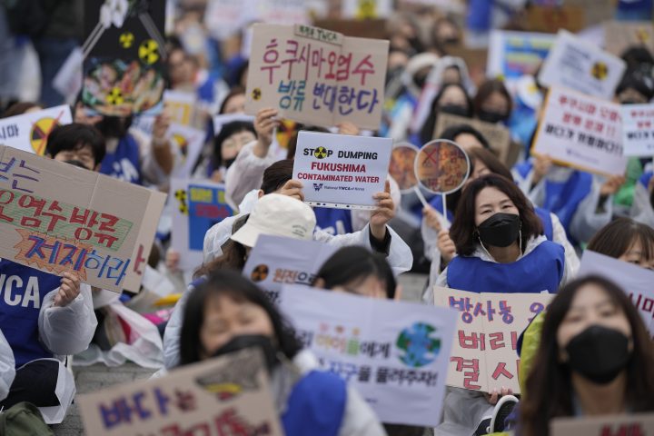 People hold banners at a rally protesting the Japanese government's decision to release treated radioactive water from the Fukushima nuclear plant