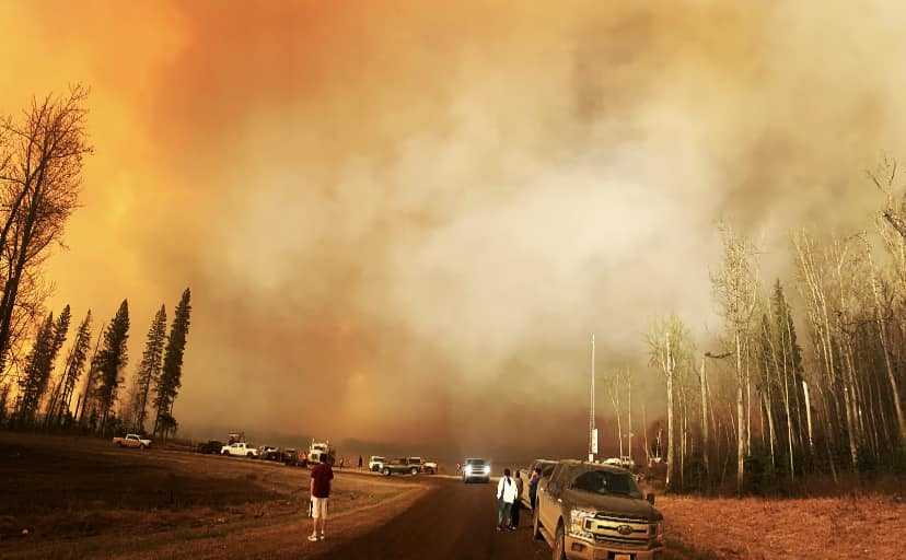 Evacuees parked on the road as wildfire smoke fills the sky near Fox Lake in northern Alberta.