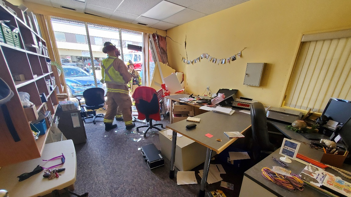 Firefighters survey the damage to the Didsbury Municipal Library on May 29 after a car crashed through the front window. 