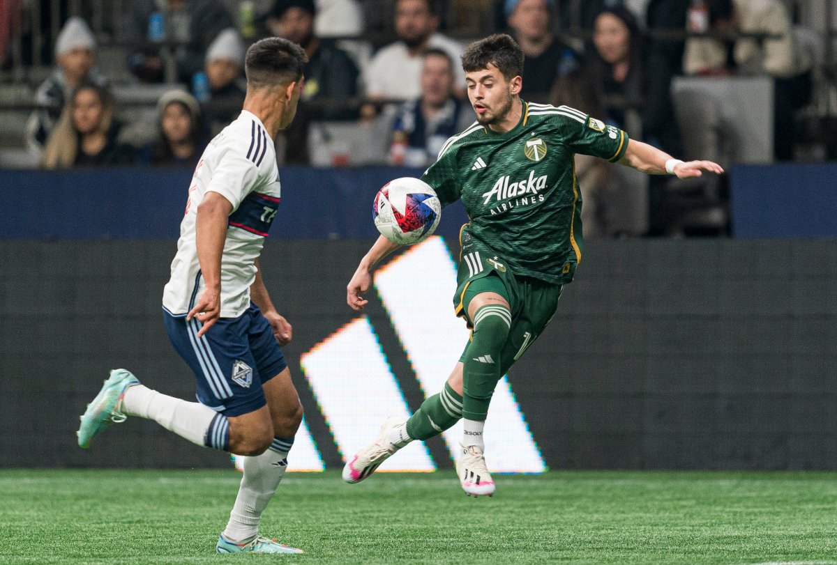 Diego Gutierrez of the Portland Timbers, right, tries to control the ball while Mathias Laborda of the Vancouver Whitecaps looks on during MLS action in Vancouver, B.C., on Saturday, April 8, 2023.