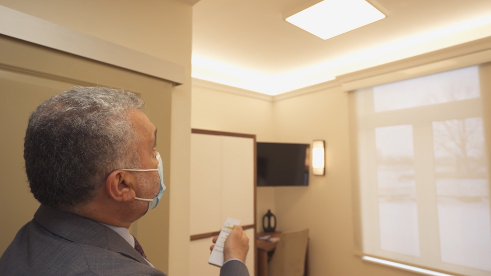 Nafia showing how biodynamic lighting works in the resident's room