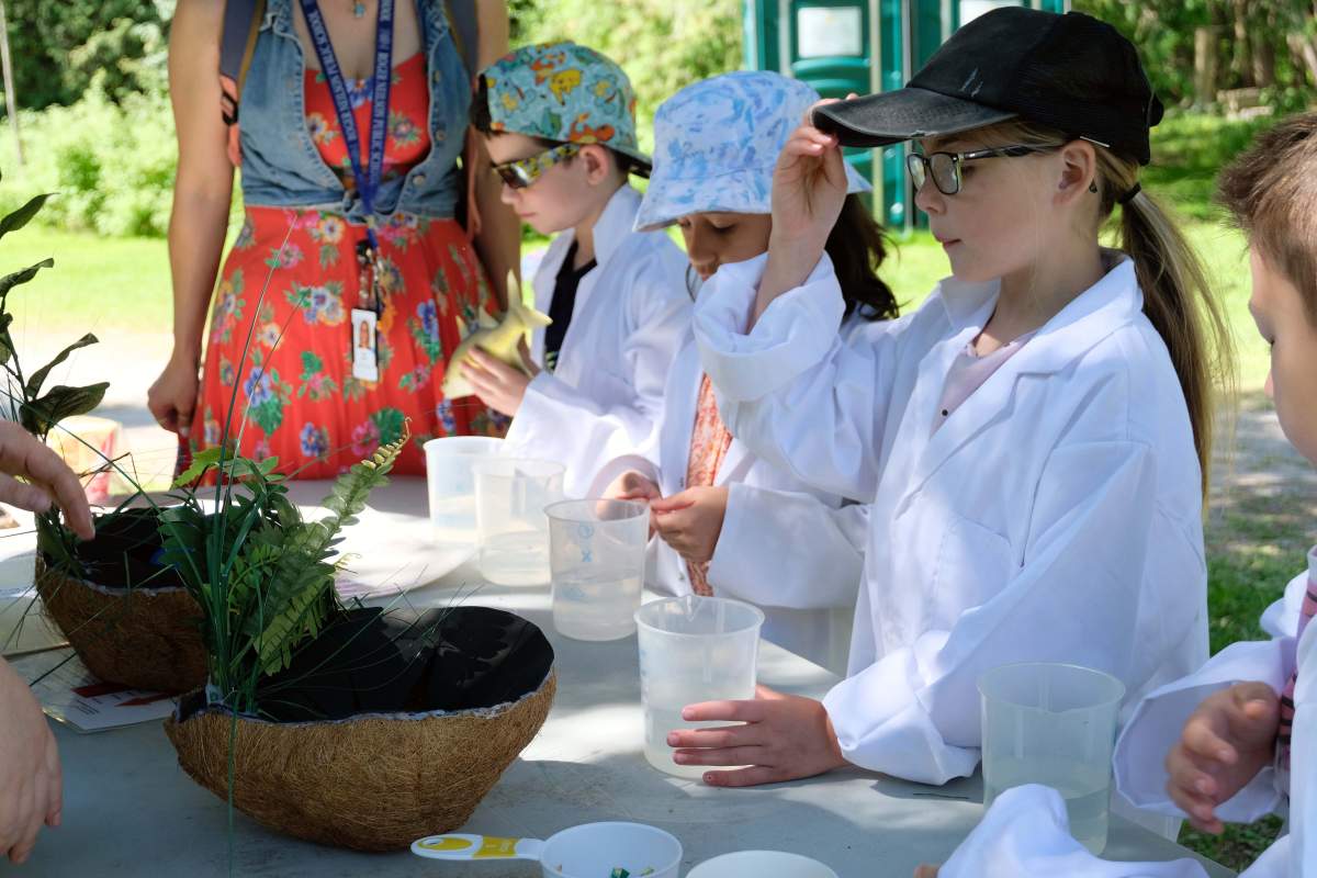 Participants on Day 1 of the Peterborough Children’s Water Festival of the PCWF don lab coats and investigate various tests on liquids to understand the concept of acidity in water.
