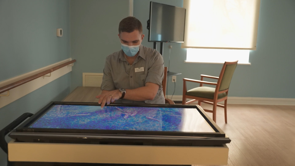 Ressam Gardens staff member, Jonathan, demoing one of the memory games for its residents