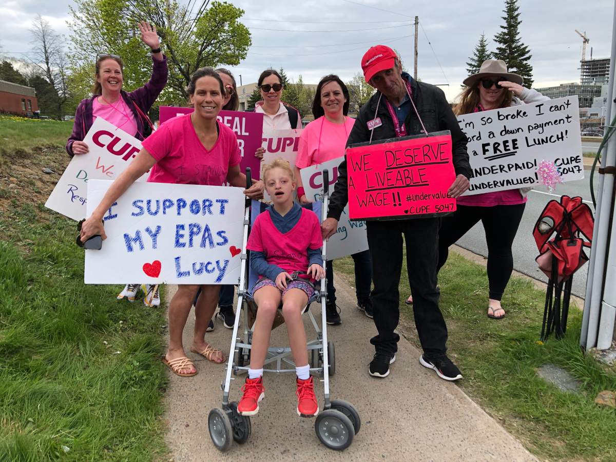 Heather Langley and her daughter Lucy stand with EPA Robert Bray on the picket lines amid the school support worker strike.