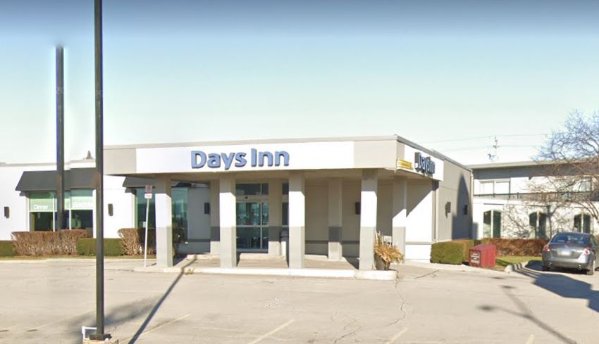 The entrance to a Days Inn hotel on a sunny day.