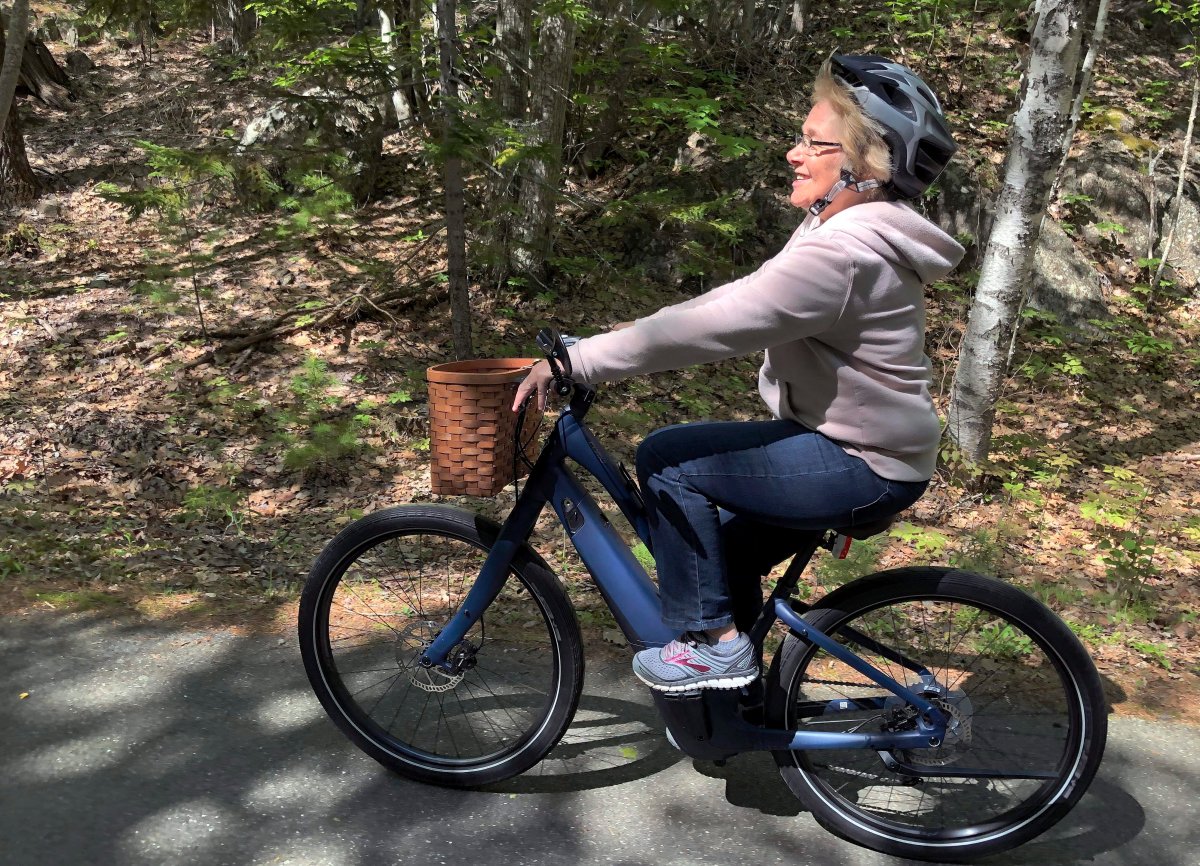 In this June 8, 2019 photo, Janice Goodwin rides her electric-assist bicycle on a paved road in Acadia National Park at Bar Harbor, Maine. 