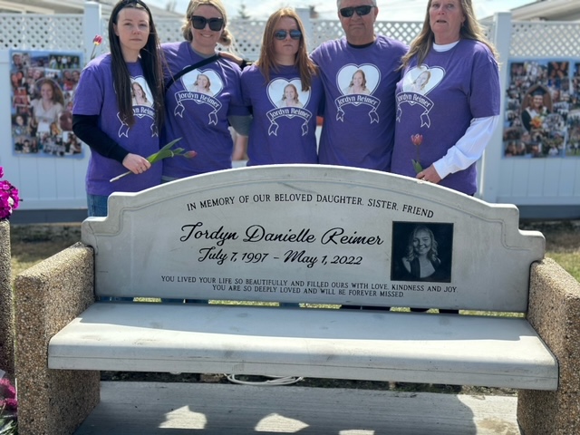 Jordyns family standing by her bench.