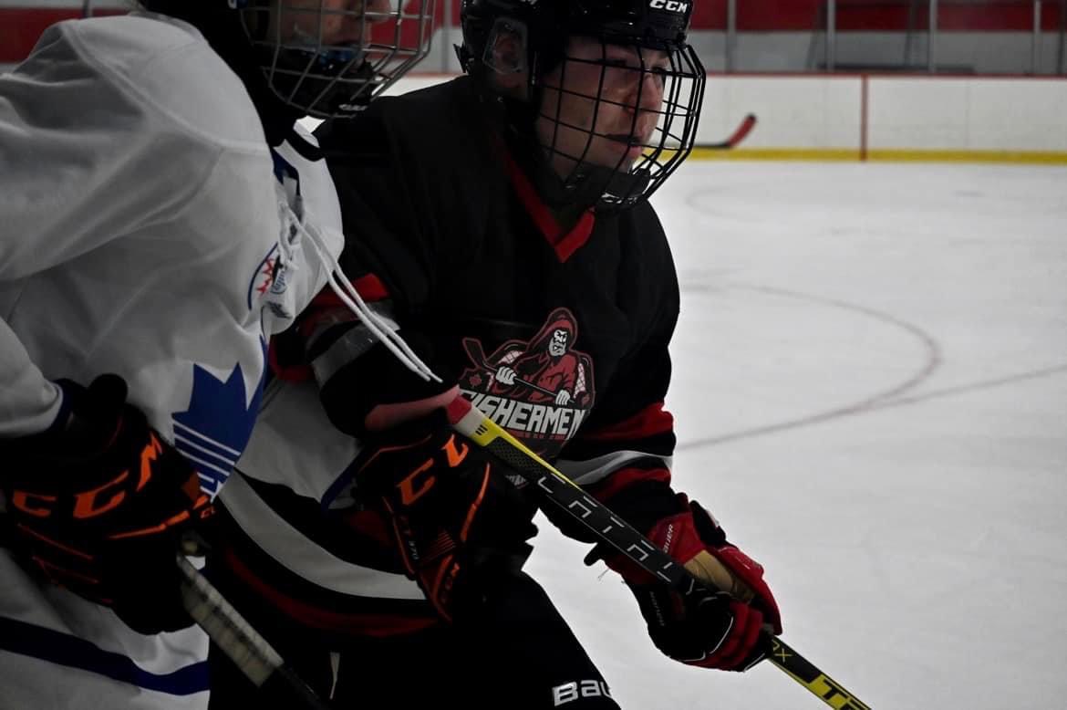 A teenager in a dark hockey jersey with red gloves on the ice