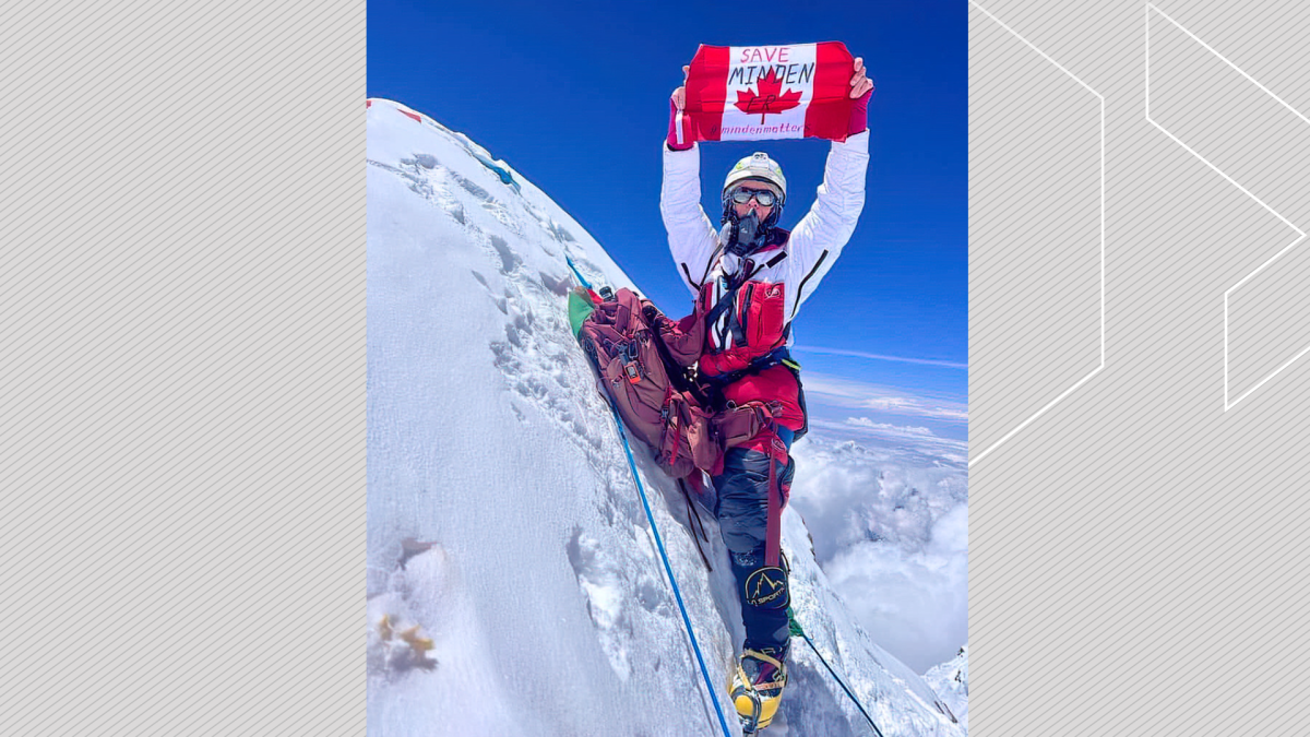 Liliya Ianovskaia unfolds a Canadian flag with "Save Minden ER" atop Lhotse in Nepal on May, 24, 2023.
