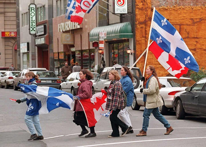 A small group of Non supporters carry Quebec and Canadian flags as they parade through the streets of Montreal on Oct. 30--. 1995 .