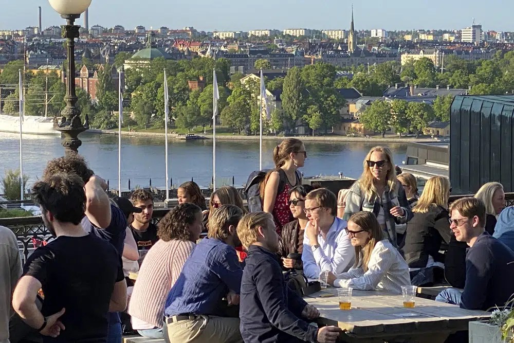 People enjoy drinks and snacks in the evening sun on a terrace overlooking Stockholm, on Tuesday, May 30, 2023. Smoking is prohibited in both indoor and outdoor areas of bars and restaurants in Sweden, which has the lowest share of smokers in the European Union.
