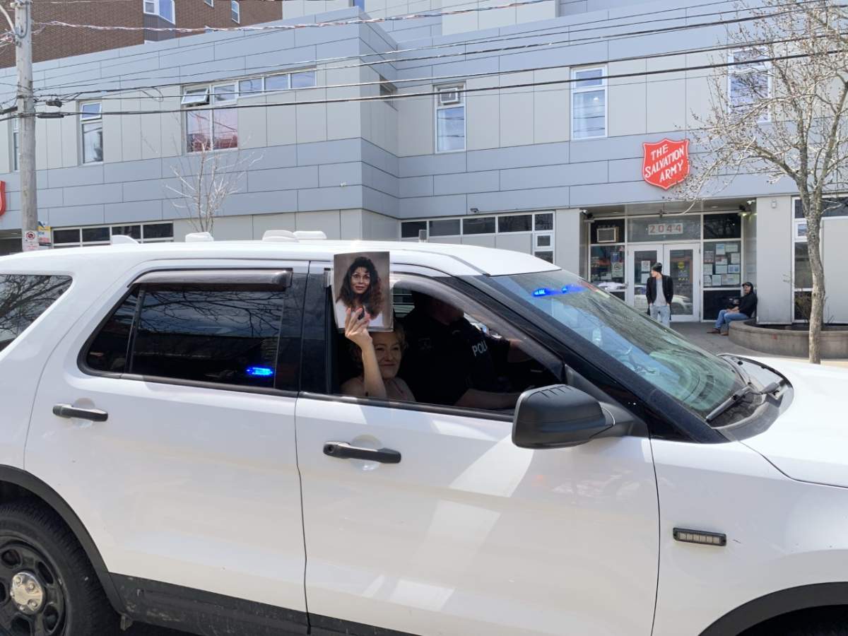 Vanessa Brooks holds up a photo of her sister, Tanya, as she drives past supporters.