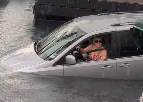 The driver smiles and appears to be unaware of what's happening at first.