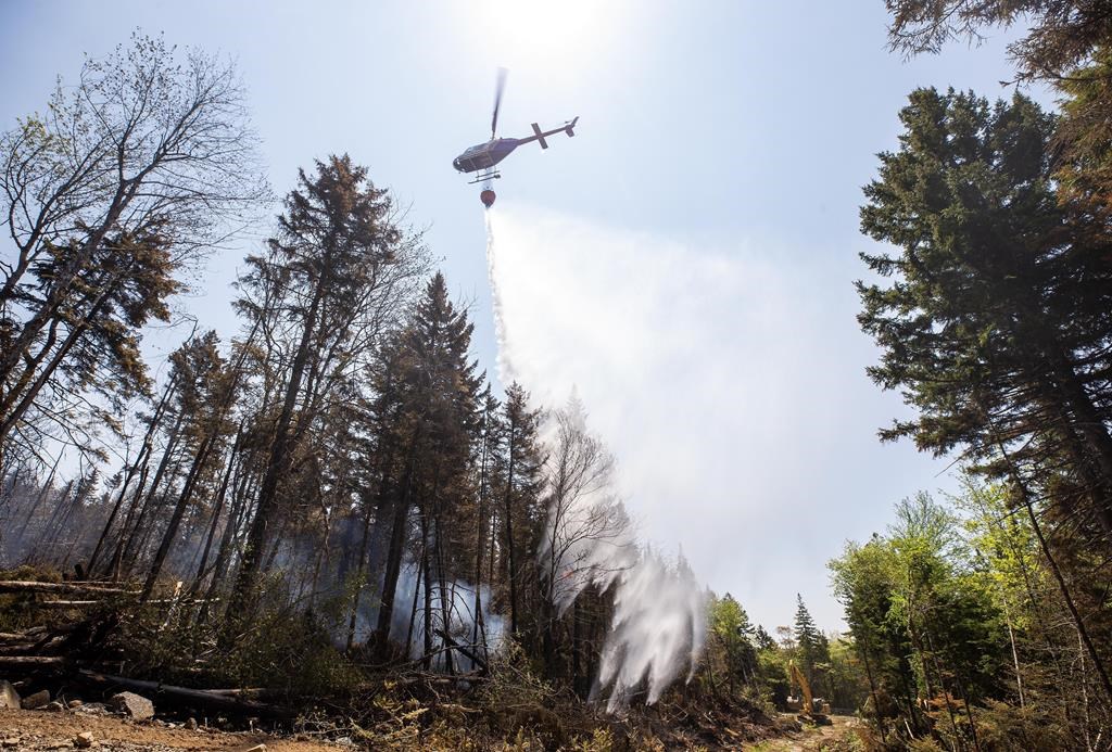 A helicopter drops water on a hot spot at a wildfire in Tantallon, N.S. in this Thursday, June 1, 2023 handout photo. THE CANADIAN PRESS/HO, Communications Nova Scotia *MANDATORY CREDIT*.