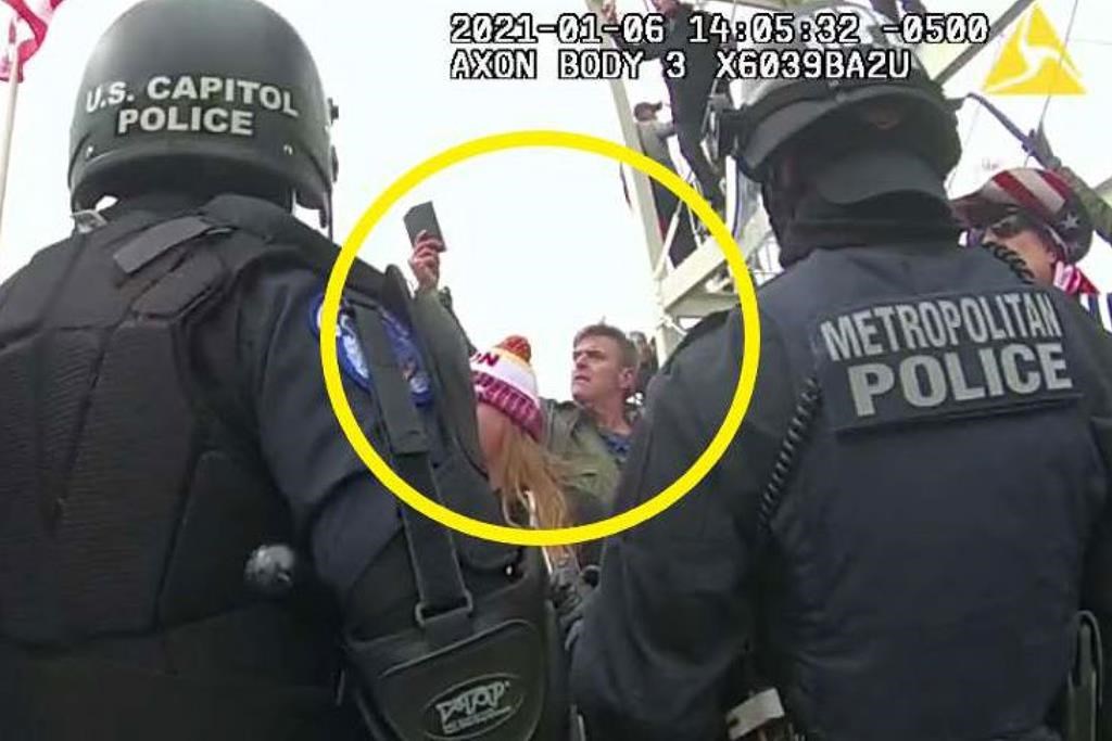 Jay Johnston is seen behind Capitol police, holding a cellphone in the air. He is circled in the image.